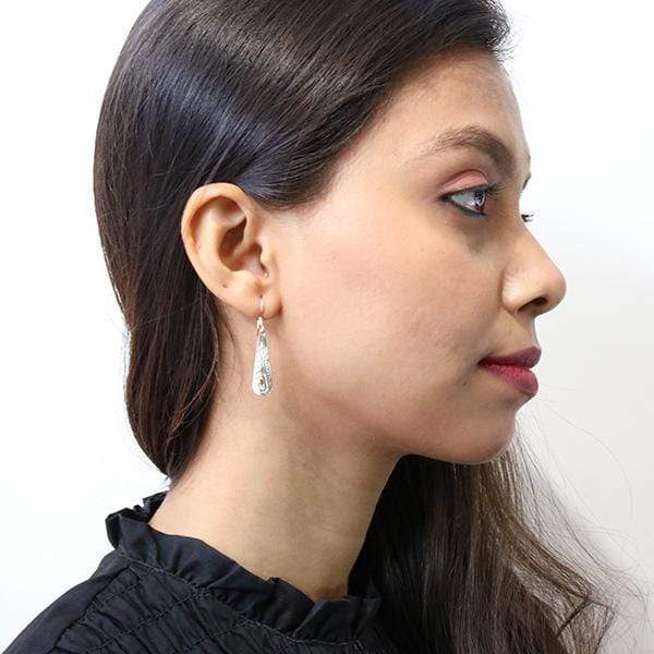 Long teardrop bear earrings hand-carved by Kwakwaka'wakw artist Carrie Matilpi. Made of sterling silver and 14K yellow gold. Each earring measures 1.55" x 0.40" including hook.