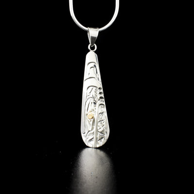 Long teardrop bear pendant hand-carved by Kwakwaka'wakw artist Carrie Matilpi. Made of sterling silver and 14K gold. Pendant measures 1.80" x 0.45" including bail. Chain not included.