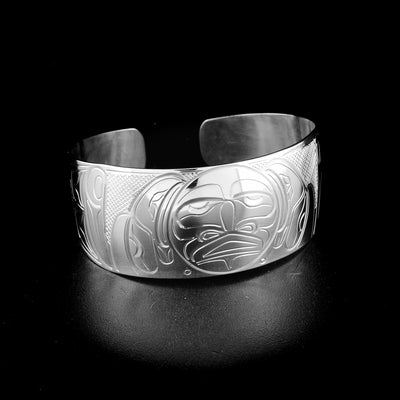 Moon and double raven bracelet hand-carved by Kwakwaka'wakw artist John Lancaster. Made of sterling silver. Bracelet is 6.1" long with 0.6" gap and has width of 1". Tapered ends.