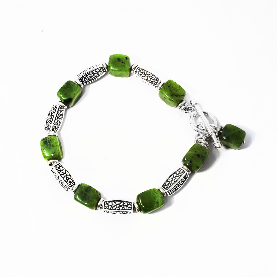 Unique Silver Pebble Pattern and BC Jade Bracelet handcrafted by artist Karley Smith. Made of sterling silver, oxidized silver and BC jade. Has sterling silver safety chain. Bracelet is 7.50" long when clasped shut and will comfortably fit a 6" to 6.50" wrist. Rectangular cube pendant with antique silver ring attached to toggle clasp measures 0.63" x 0.25" including bail.