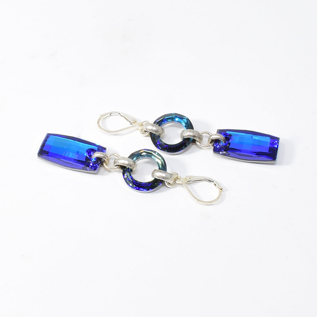 Dazzling lever back earrings handcrafted by artist Karley Smith. Made of Swarovski Crystal and sterling silver. Ear hooks are sterling silver. Each earring measures 2.35" x 0.55" including hook.