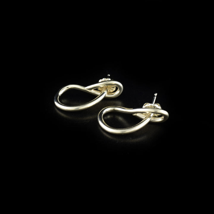 Delicate stud earrings handcrafted by artist Lynda Constantine. Made of sterling silver. Each earring measures 0.94" x 0.25".