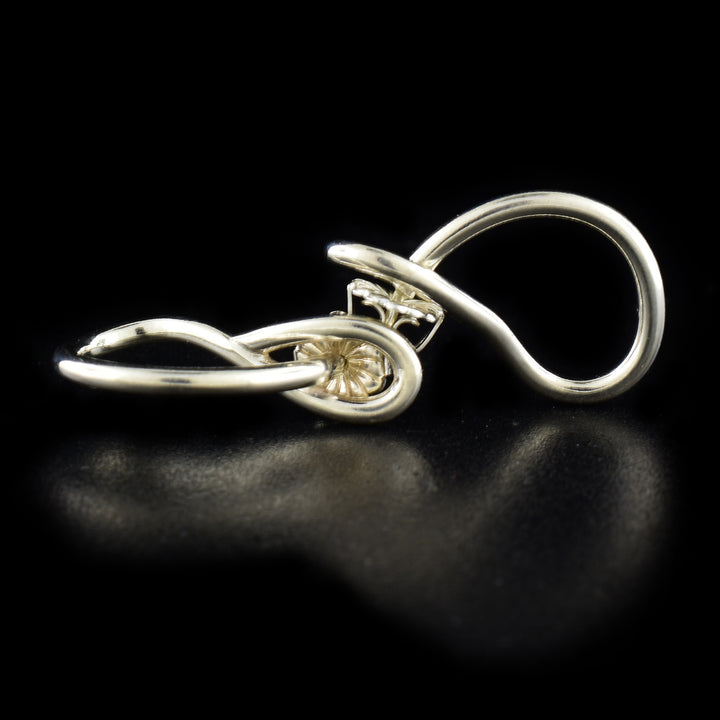 Delicate stud earrings handcrafted by artist Lynda Constantine. Made of sterling silver. Each earring measures 0.94" x 0.25".