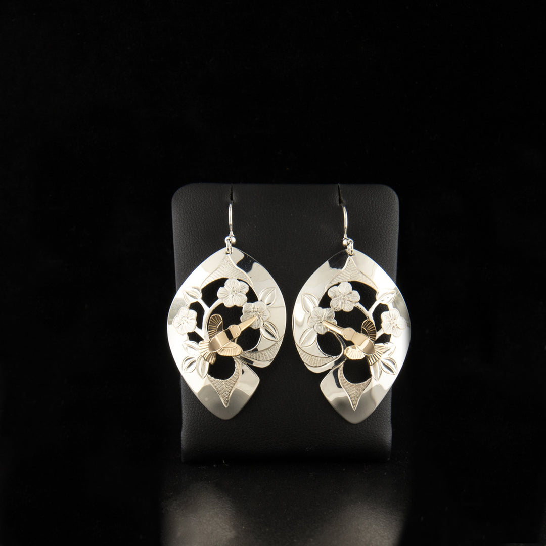Sterling silver and 14K gold hummingbird and roses earrings hand-carved by artist Arlene Howk. Each earring measures 2" x 1" including hook.