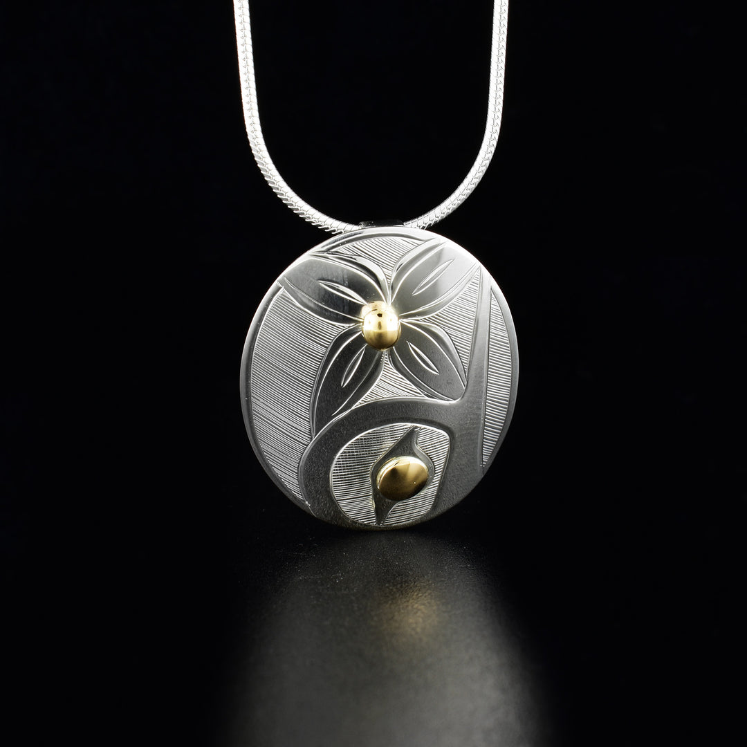 Sterling silver and 14K gold oval hummingbird pendant hand-carved by Haisla artist Hollie Bartlett. Pendant measures 1.19" x 1". Hidden bail on back. Chain not included.