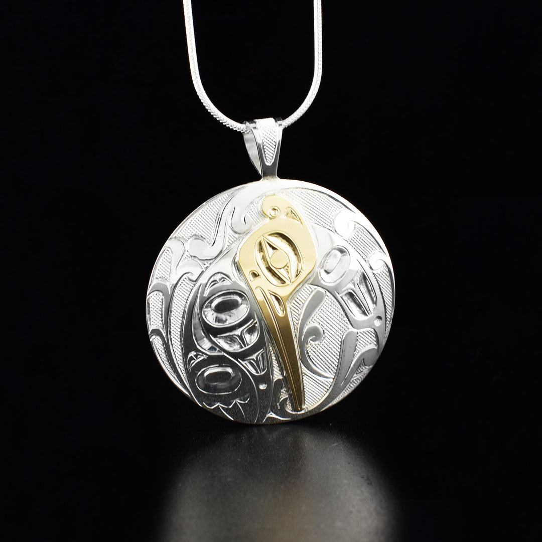 Sterling silver and 14K gold round hummingbird pendant hand-carved by artist Ivan Thomas. Pendant measures 1.88" x 1.56" including bail. Chain not included.