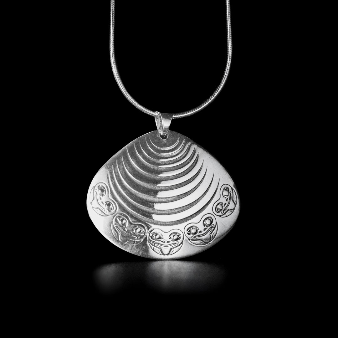 Sterling silver and 18K gold Clam and Frog pendant. Design depicts a clam with frogs decorating the bottom. Eyes of the frogs are made from 18K gold and rest of piece is sterling silver. Measures 1.25" x 1.50". Chain not included.