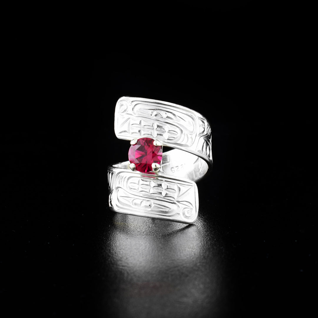 Bear wrap ring hand-carved by Coast Salish and Cree artist Richard Lang. Made of sterling silver and a lab-grown stone. Band is 0.31" wide, with the flexible wrap design giving the ring a comfortable fit. Size 7.