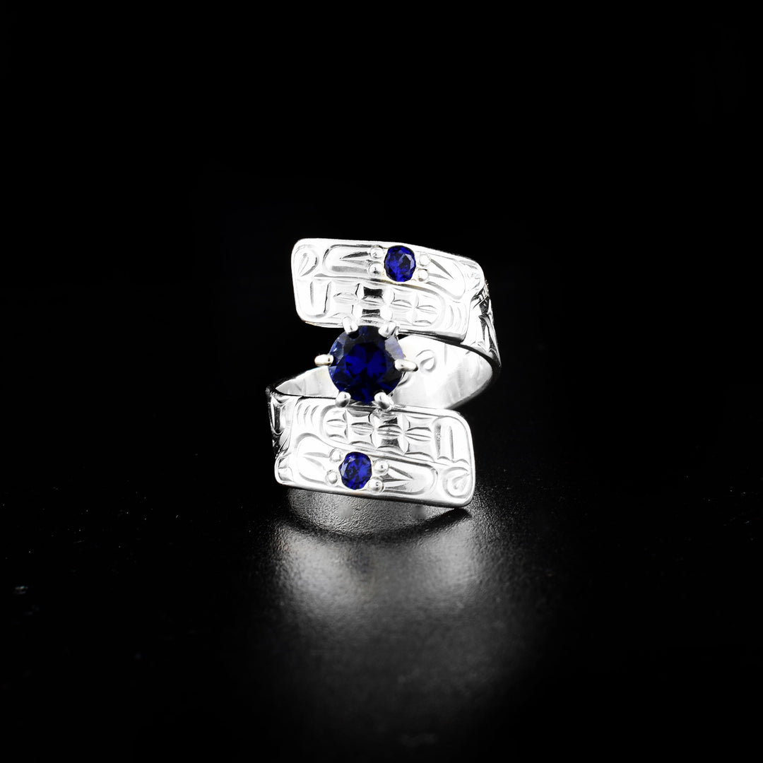 Beaver wrap ring hand-carved by Coast Salish and Cree artist Richard Lang. Made of sterling silver and three lab-grown stones. Band is 0.31" wide, with the flexible wrap design giving the ring a comfortable fit. Size 8.