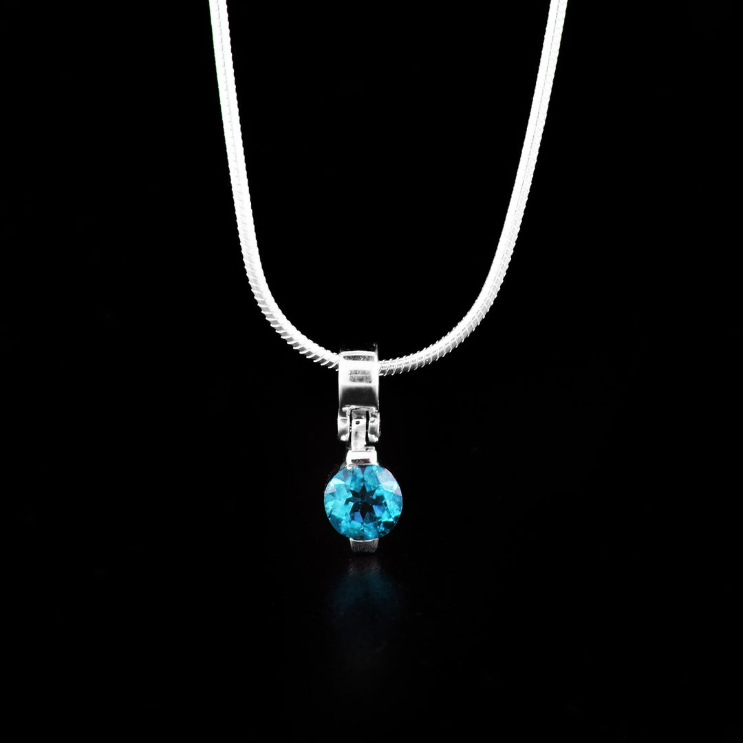 This topaz pendant is made from sterling silver and a blue topaz gemstone. The pendant is made from a topaz gem set onto sterling silver with a simple bail.