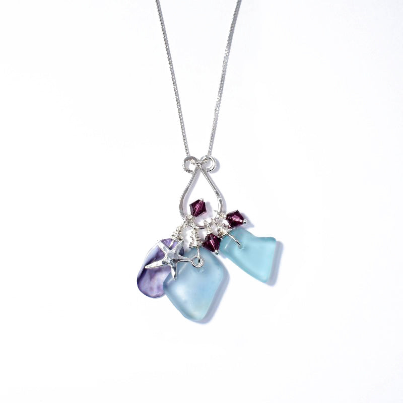Bounty cluster pendant necklace handcrafted by artist Kim Naylor. Made of sterling silver, sea glass, seashells, Swarovski Crystal and sterling silver. Sterling silver chain included. Chain is 18.50" long. Pendant measures 2" x 1.75".