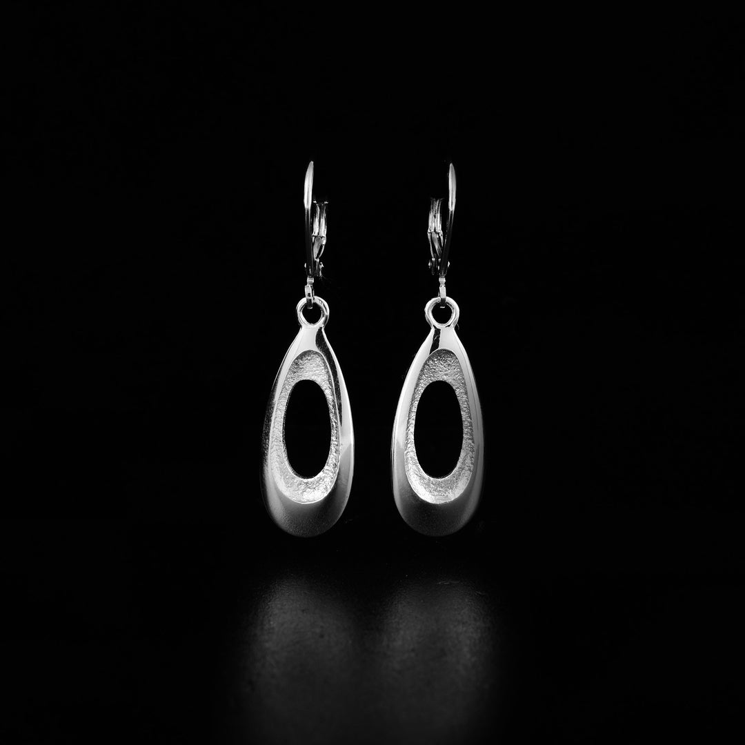 These sterling silver teardrop earrings have teardrop shaped hangs with cutouts in the center. The inside of the hangs are tapered and have a textured surface.