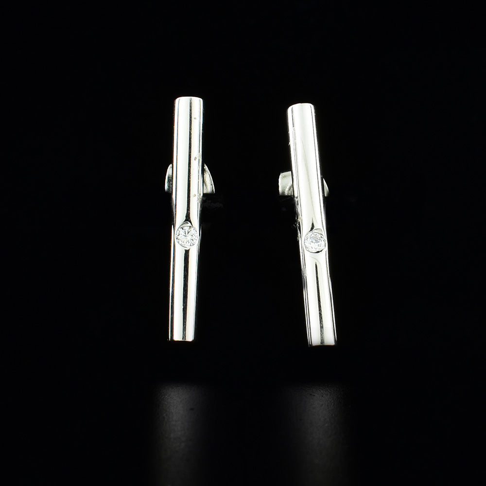 These sterling silver and cubic zirconia stud earrings have cylinder poles with the gems embedded in the center of them.