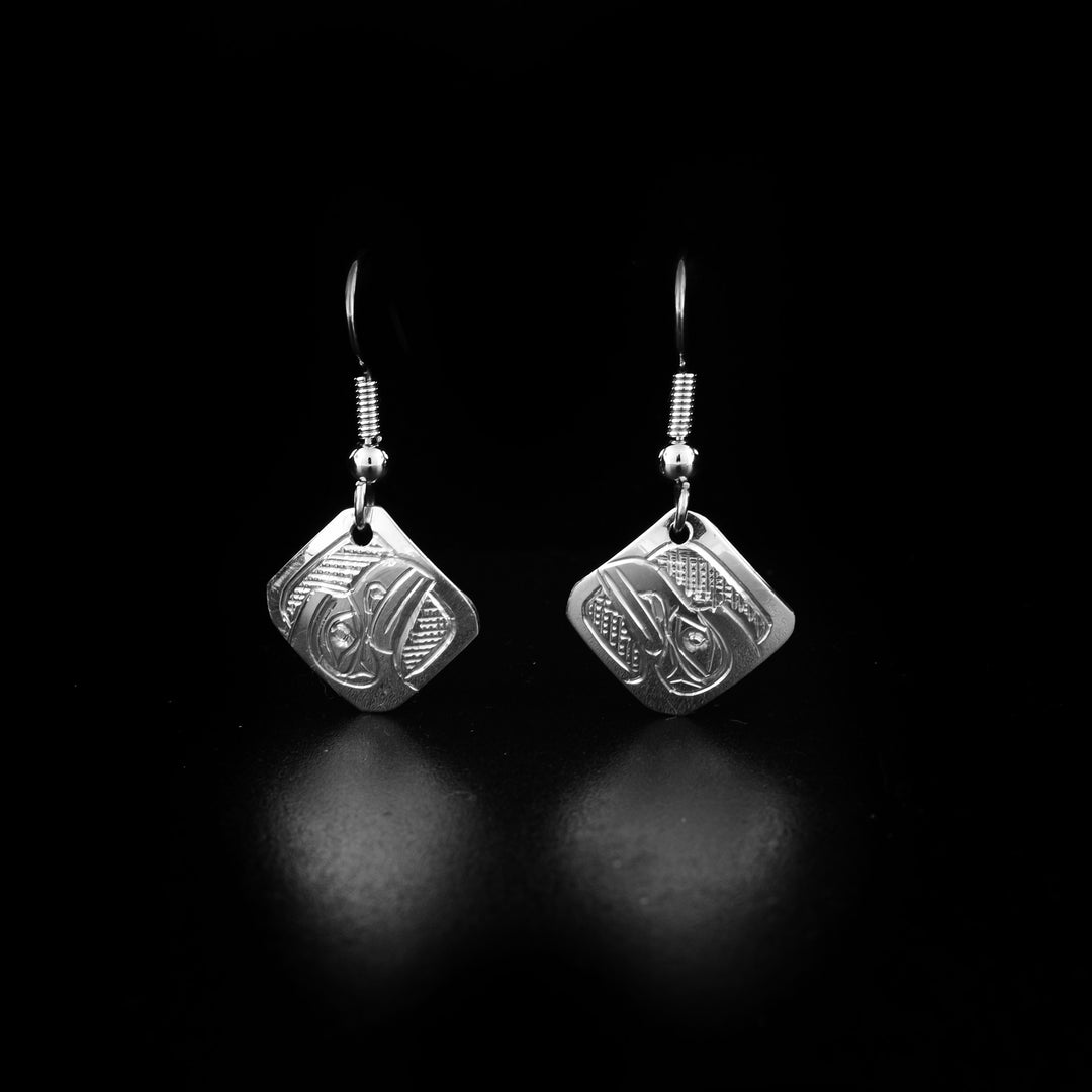 These dangling Raven earrings are made from sterling silver and have small, diamond shaped hangs. There are depictions of the Raven carved into the surface of the hangs.