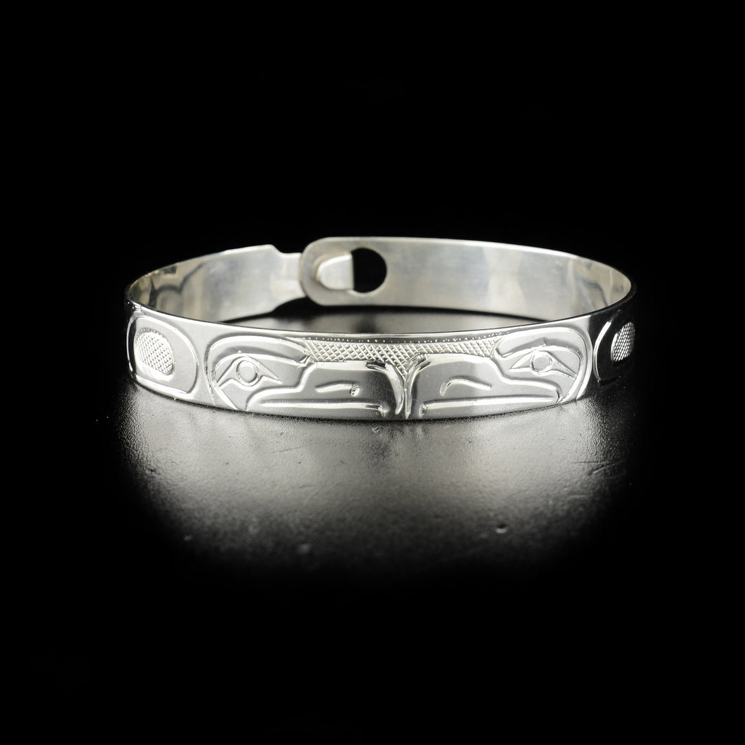 Double eagle clasp bracelet hand-carved by Kwakwaka'wakw artist Norman Seaweed. Made of sterling silver. Bracelet has circumference of 7.63" when clasped shut. The clasp design makes it fit like a smaller style bangle and can fit various wrist sizes. Bracelet has width of 0.38".