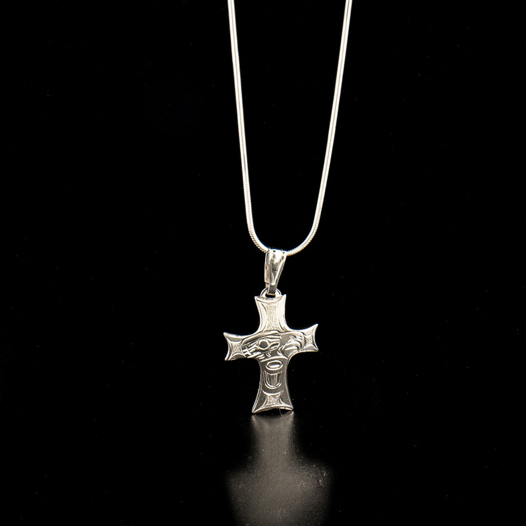 Sterling silver eagle cross pendant hand-carved by Kwakwaka'wakw artist Harold Alfred. Pendant measures 1.50" x 0.88" including bail. Chain not included.