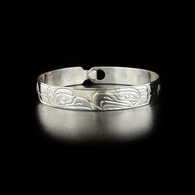 Eagle and raven clasp bracelet hand-carved by Kwakwaka'wakw artist Norman Seaweed. Made of sterling silver. Bracelet has circumference of 7.75" when clasped shut. The clasp design makes it fit like a smaller style bangle and can fit various wrist sizes. Bracelet has width of 0.38".