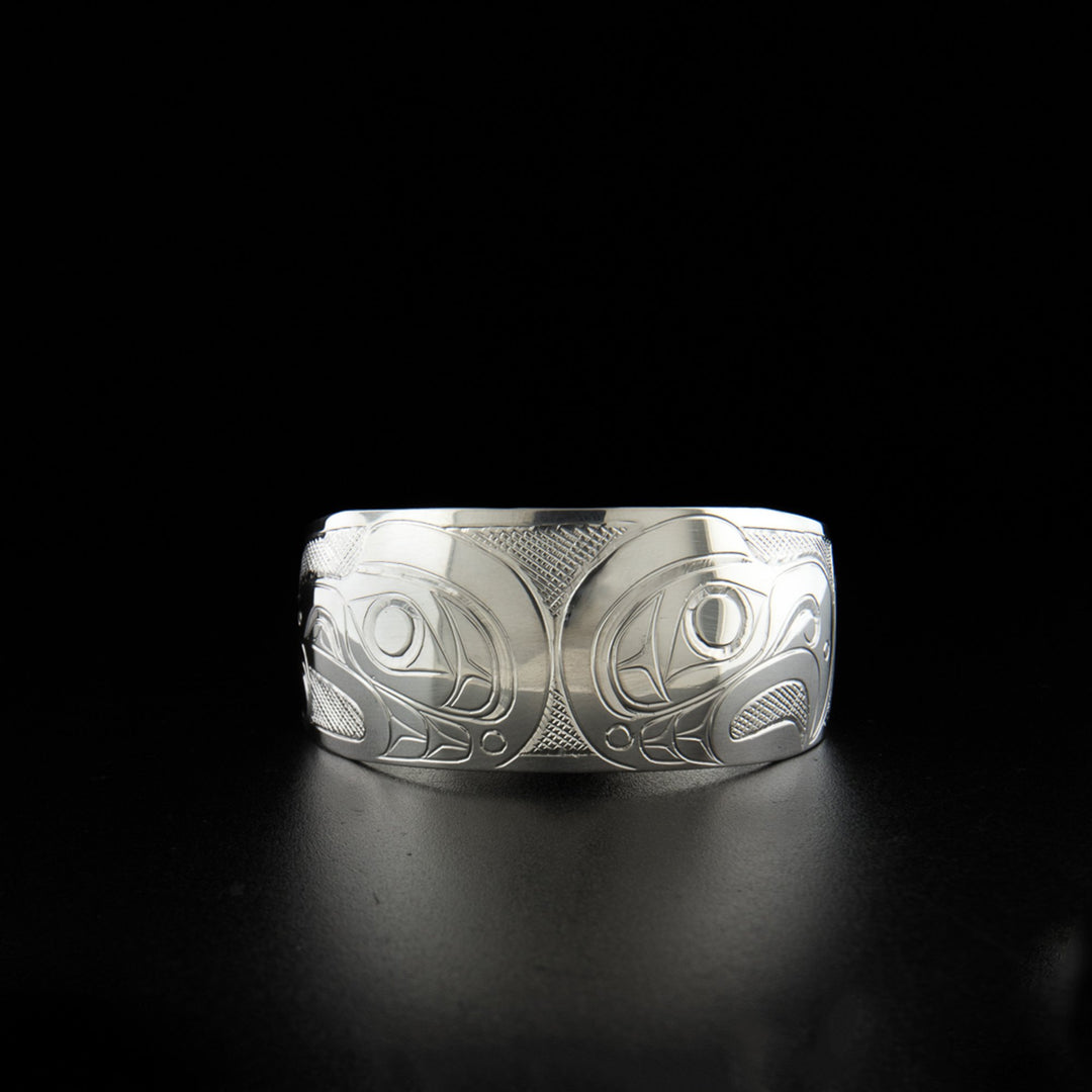 Sterling silver tapered eagle and raven bracelet hand-carved by Kwakwaka'wakw artist Don Lancaster. 6.25" long with 0.69" gap. 1" wide.