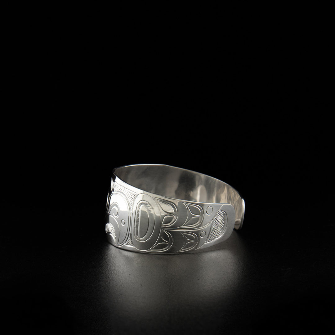 Sterling silver tapered eagle and raven bracelet hand-carved by Kwakwaka'wakw artist Don Lancaster. 6.25" long with 0.69" gap. 1" wide.