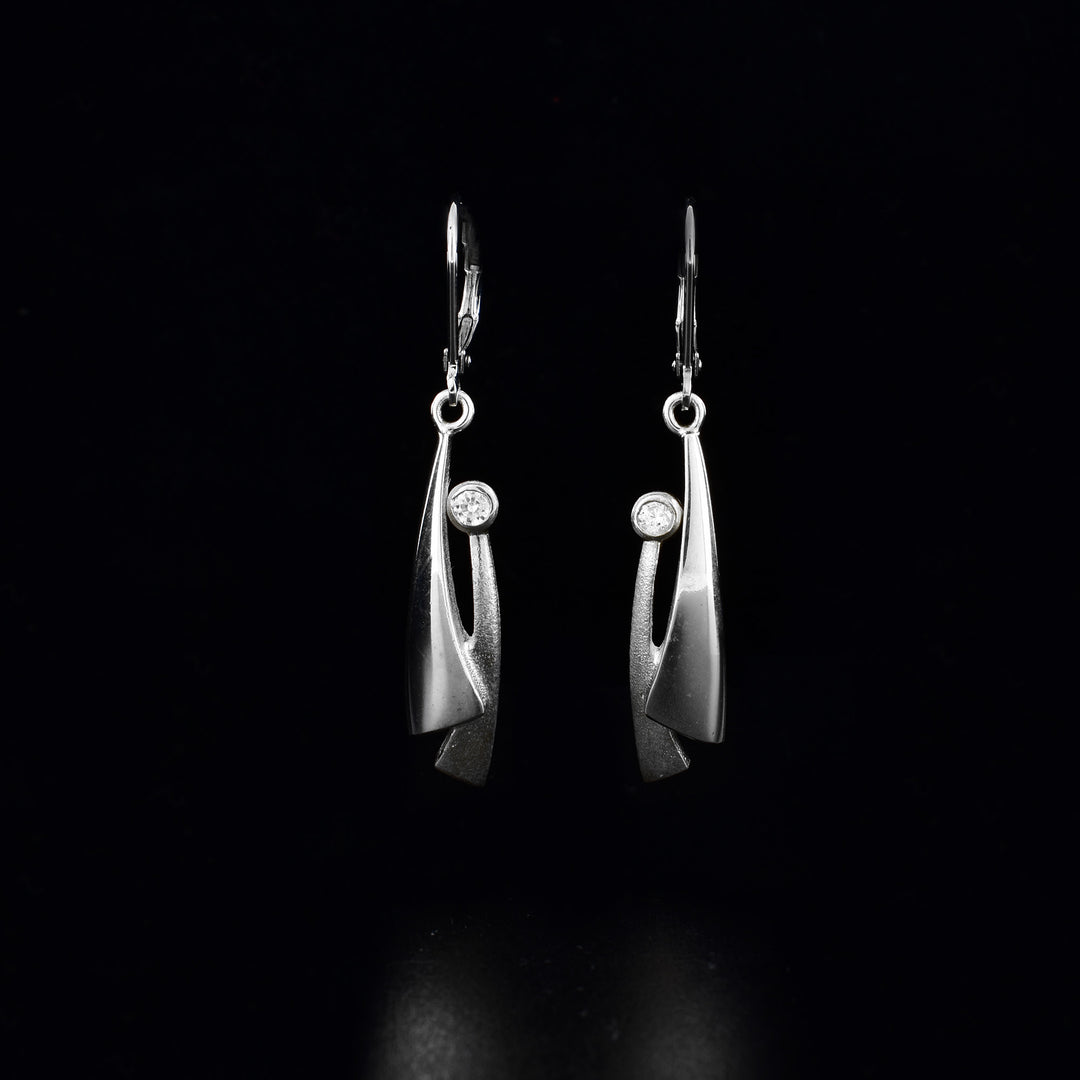 These sterling silver and cubic zirconia earrings have hangs with two tapered pieces. The hangs are silver and there is a cubic zirconia gemstone at the top of the tapered piece.