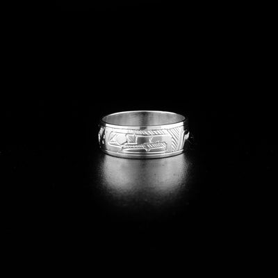 Sterling Silver 5/16" Eagle Ring by Jeffrey Pat. In the center of the ring there is the profile of an eagle's head facing towards the right. Along the rest of the ring the artist has hand-carved intricate designs representing the feathers and body of the eagle.