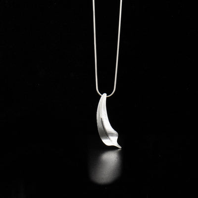 Sterling silver flicker feather pendant hand-carved by Tlingit artist Fred Myra. Pendant measures 1.88" x 0.56". Hidden bail on back. Chain not included.