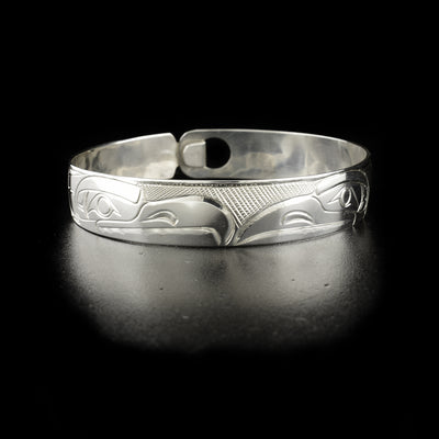Raven and eagle clasp bracelet hand-carved by Kwakwaka'wakw artist Norman Seaweed. Made of sterling silver. Bracelet has circumference of 7.75" when clasped shut. The clasp design makes it fit like a smaller style bangle and can fit various wrist sizes. Bracelet has width of 0.5".