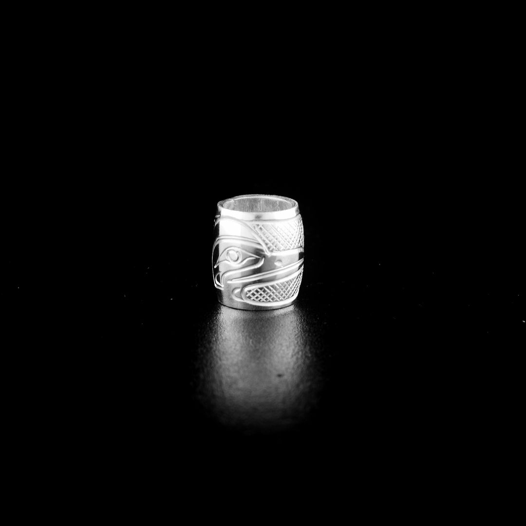 This Heron charm bead is made from sterling silver and is longer than it is wide. There is a depiction of the Heron carved into the surface of the bead.