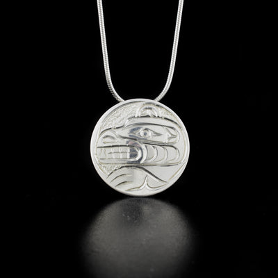 Round bear pendant hand-carved by Kwakwaka'wakw artist Paddy Seaweed. Made of sterling silver. Pendant is 1" in diameter. Hidden bail on back. Chain not included.
