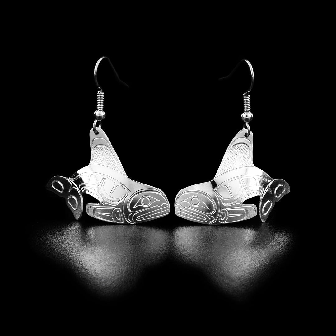 Each of these orca earrings is shaped like a swimming orca with a large tail and two large fins. The orca is showing its teeth.