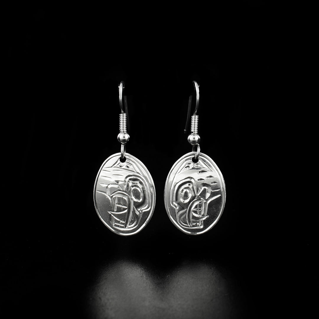 Delicate oval bear earrings hand-carved by Heiltsuk artist Ivan Wilson. Made of sterling silver. Each earring measures 1.40" x 0.60" including hook.