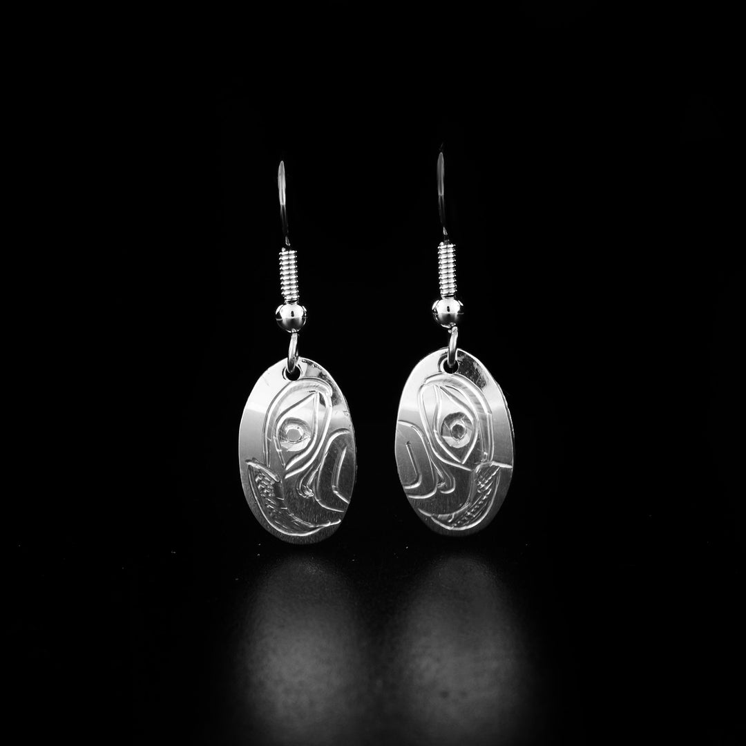These dangling Eagle earrings are made from sterling silver and have small oval shaped hangs. There are depictions of the Eagle carved into the surface of them.