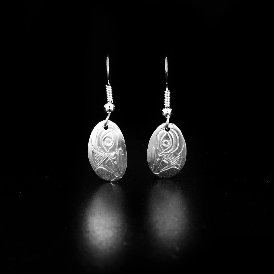 These dangling Hummingbird earrings are made from sterling silver and have small, oval shaped hangs. There are depictions of the Hummingbird carved into the surface of the hangs.