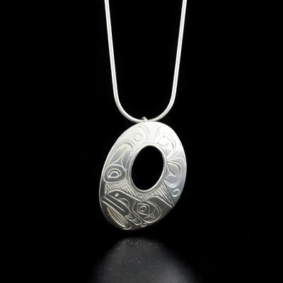 Sleek oval raven cut out pendant hand-carved by Kwakwaka'wakw artist Don Lancaster. Made of sterling silver. Pendant measures 1.38" x 1". Hidden bail on back. Chain not included.