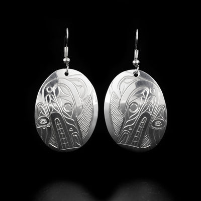 Stunning oval wolf earrings hand-carved by Kwakwaka'wakw artist Don Lancaster. Made of sterling silver. Each earring measures 1.94" x 1" including hook.