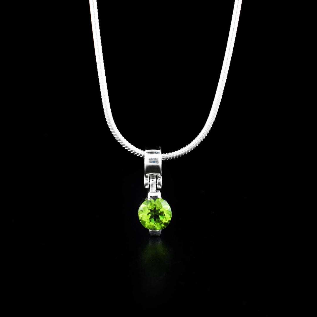 This peridot pendant is made from sterling silver and a peridot gemstone. The pendant is made from a peridot gem set onto sterling silver with a simple bail.