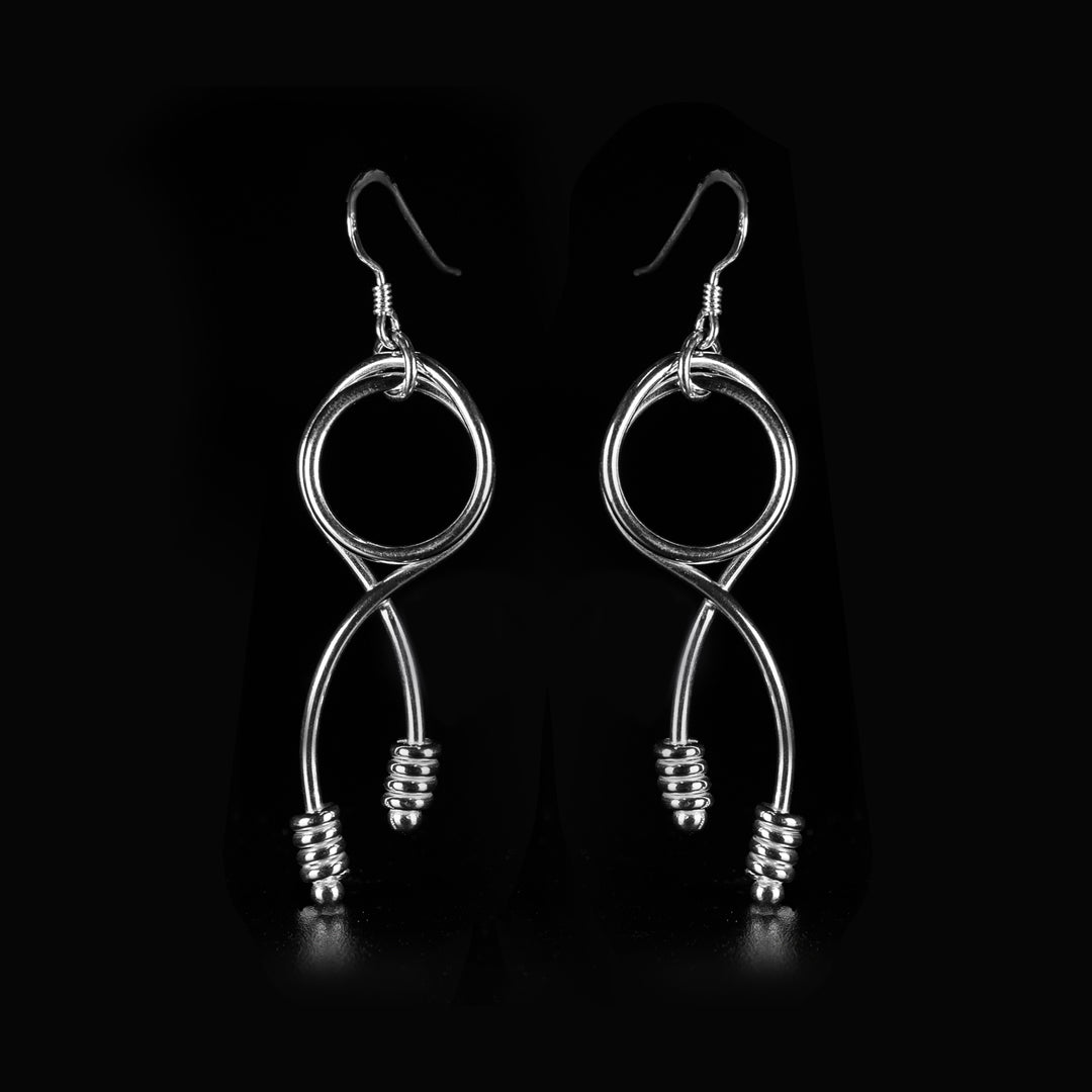 These dangle hoop earrings are made from sterling silver and have hangs that are shaped like knots. The hangs are made form wires and have designs at the bottom of them.
