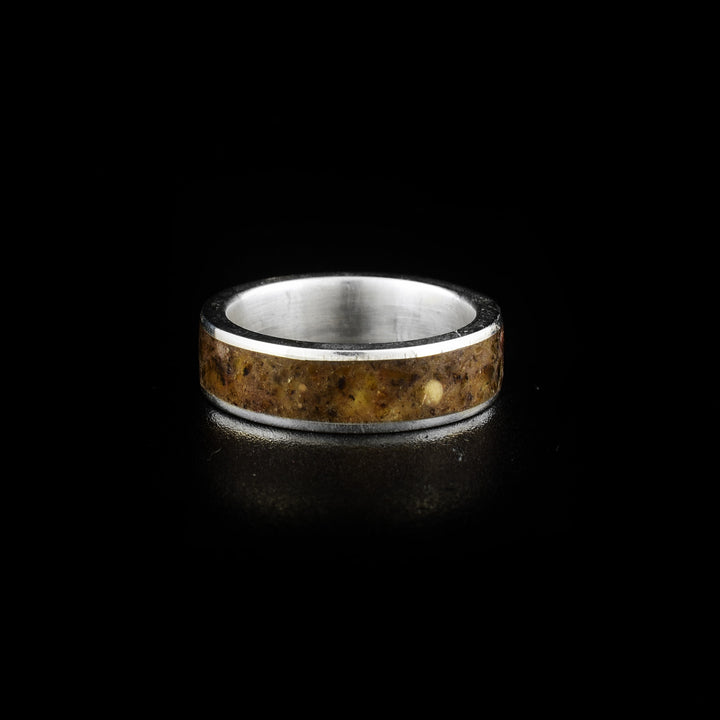 This mens amber ring is made from sterling silver, fossilized amber and has a wide silver band. There is a band running through the middle of the piece made from pieces of the amber that are set in resin.