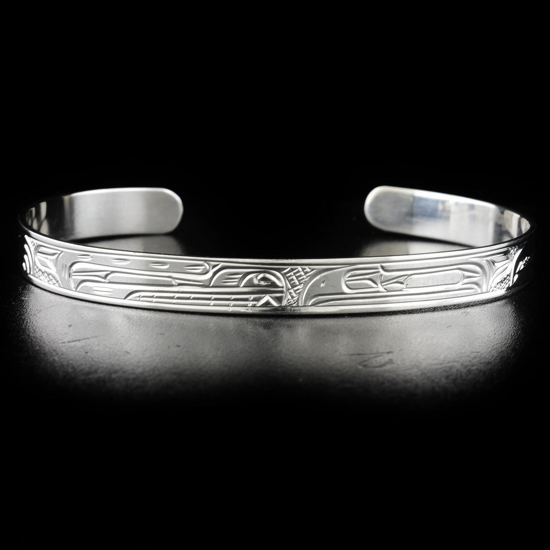 Bear and raven bracelet hand-carved by Kwakwaka'wakw artist Victoria Harper. Made of sterling silver. Bracelet is 6.20" long with 1" gap and has width of 0.25".