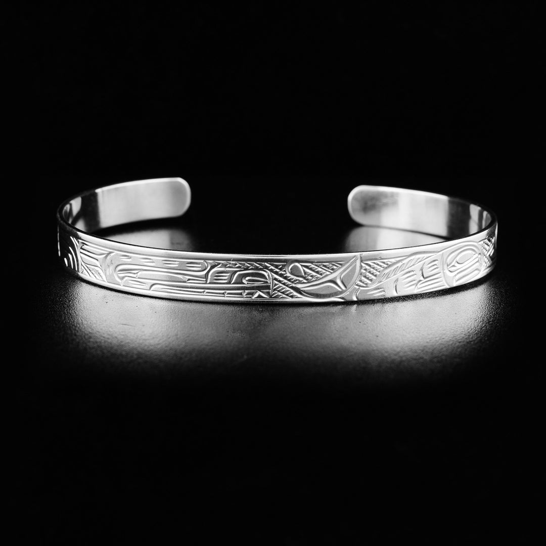 This Salmon and Bear bracelet cuff is made from sterling silver and has a thin band with a gap in the back. There are gorgeous depictions of the Bear and the Salmon carved into the surface of the band.