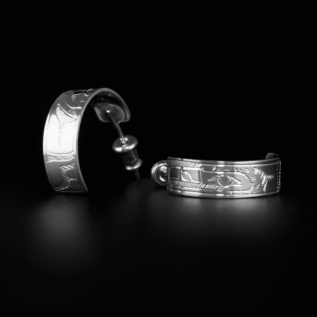 These unique hoop stud earrings are made from sterling silver and have wide bands curved into hoops with small gaps in the back. There are depictions of the Eagle carved into the surface of the band.