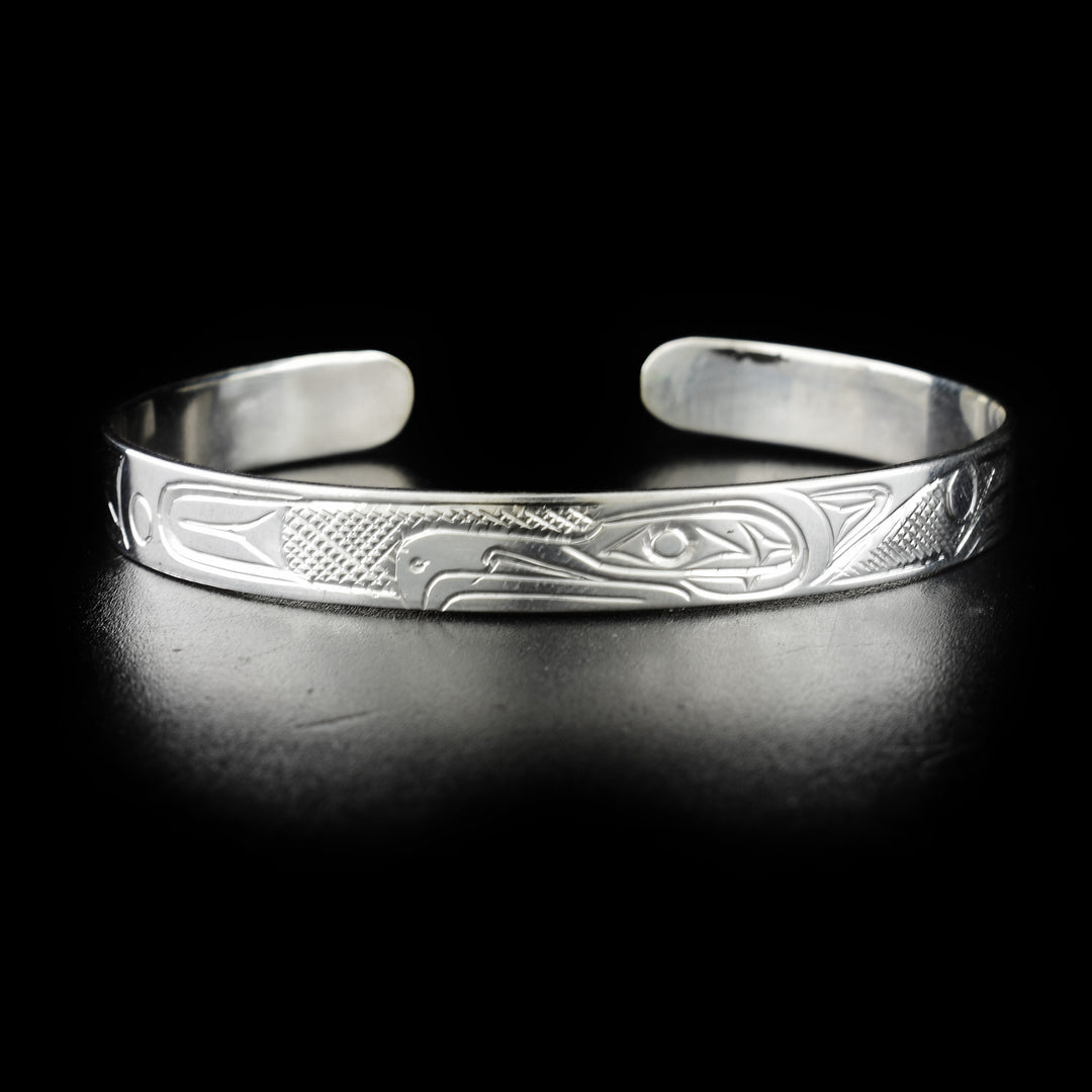 Sleek Thunderbird bracelet hand-carved by Kwakwaka'wakw artist Don Lancaster. Made of sterling silver. Bracelet is 6.20" long with 0.80" gap and has width of 0.25".