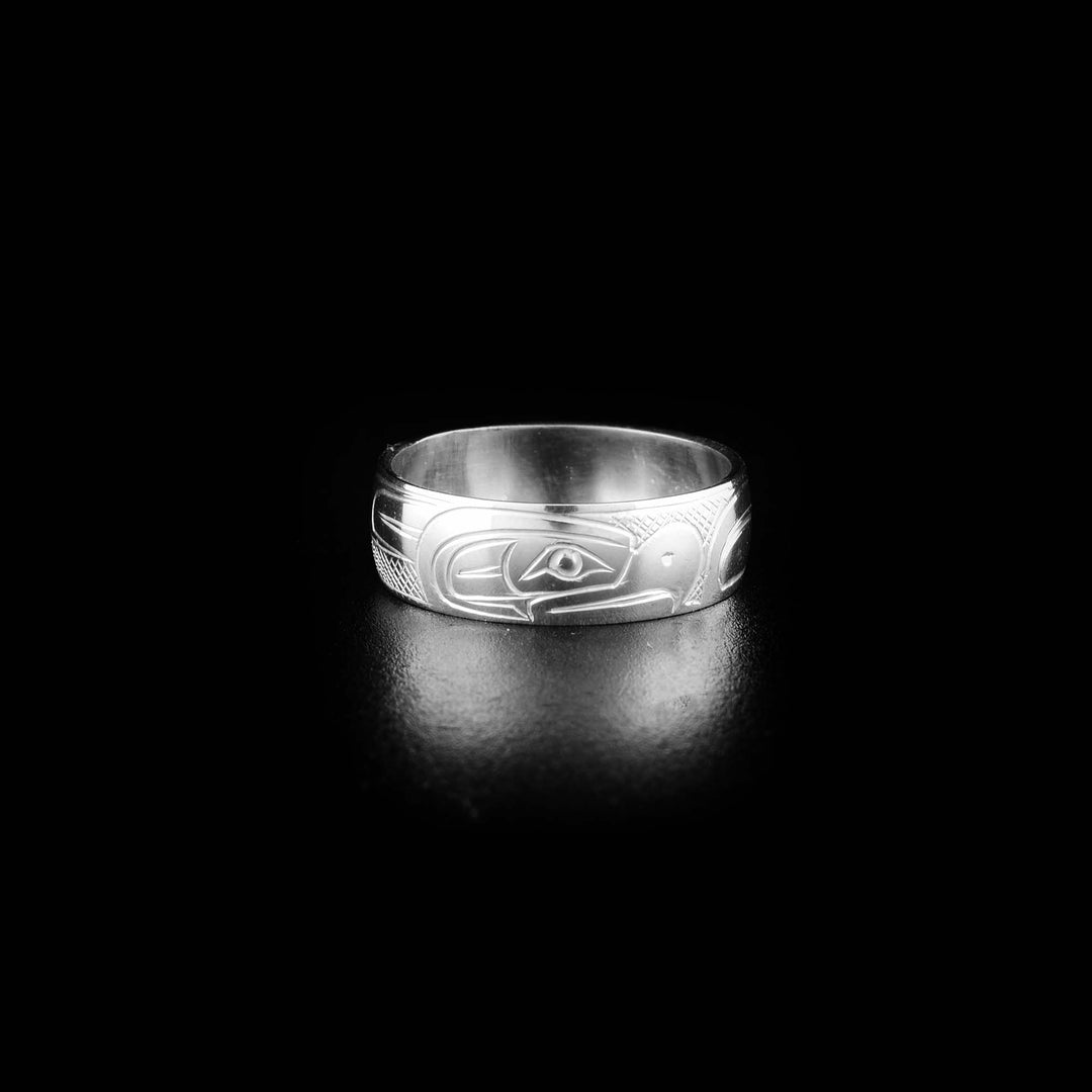 This Thunderbird ring is made from sterling silver and has the profile of a Thunderbird's head facing towards the right with a pointy beak. The rest of the ring has carved designs representing the feathers and wings.