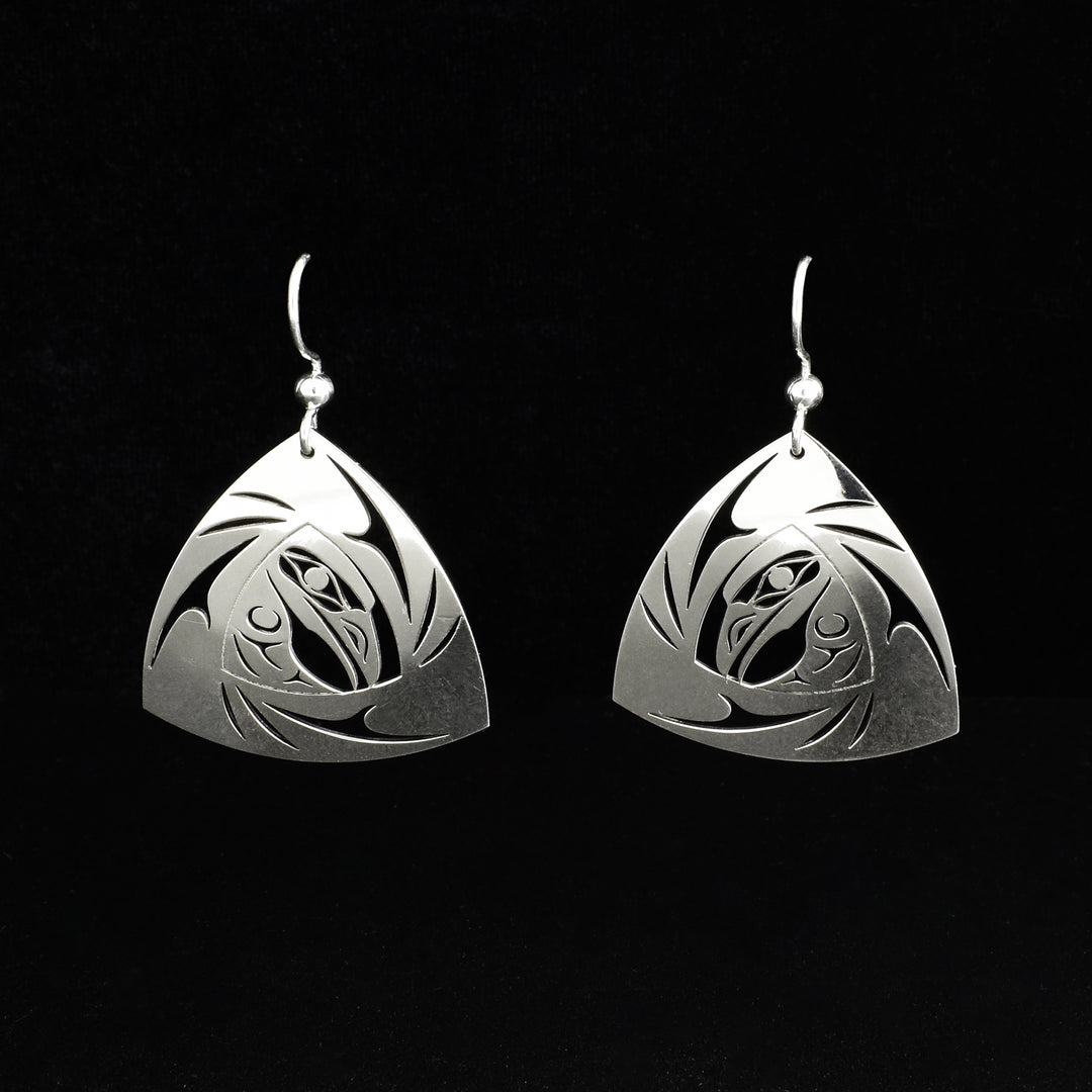 These triangle dangle earrings are made from sterling silver and have rounded, triangular shaped hangs. There are cut-out designs that have been cast into the surface of the hangs depicting the Raven in a swirl.
