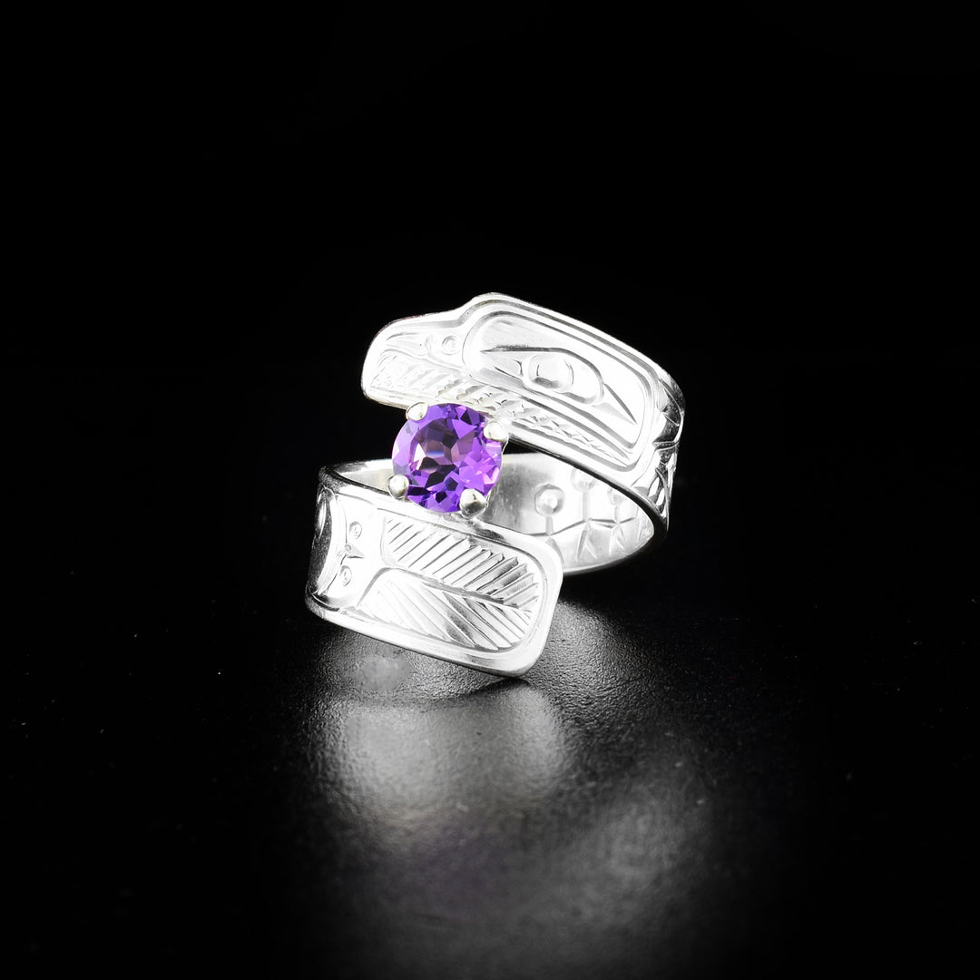 Raven wrap ring hand-carved by Coast Salish and Cree artist Richard Lang. Made of sterling silver and a lab-grown stone. Band is 0.31" wide, with the flexible wrap design giving the ring a comfortable fit. Size 8.