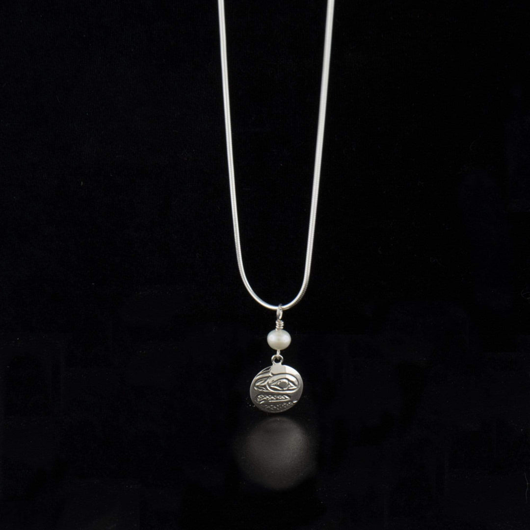 Sterling silver round raven pendant with freshwater pearl hand-carved by Kwakwaka'wakw artist Carrie Matilpi. Pendant measures 1.25" x 0.56" including bail. Chain not included.