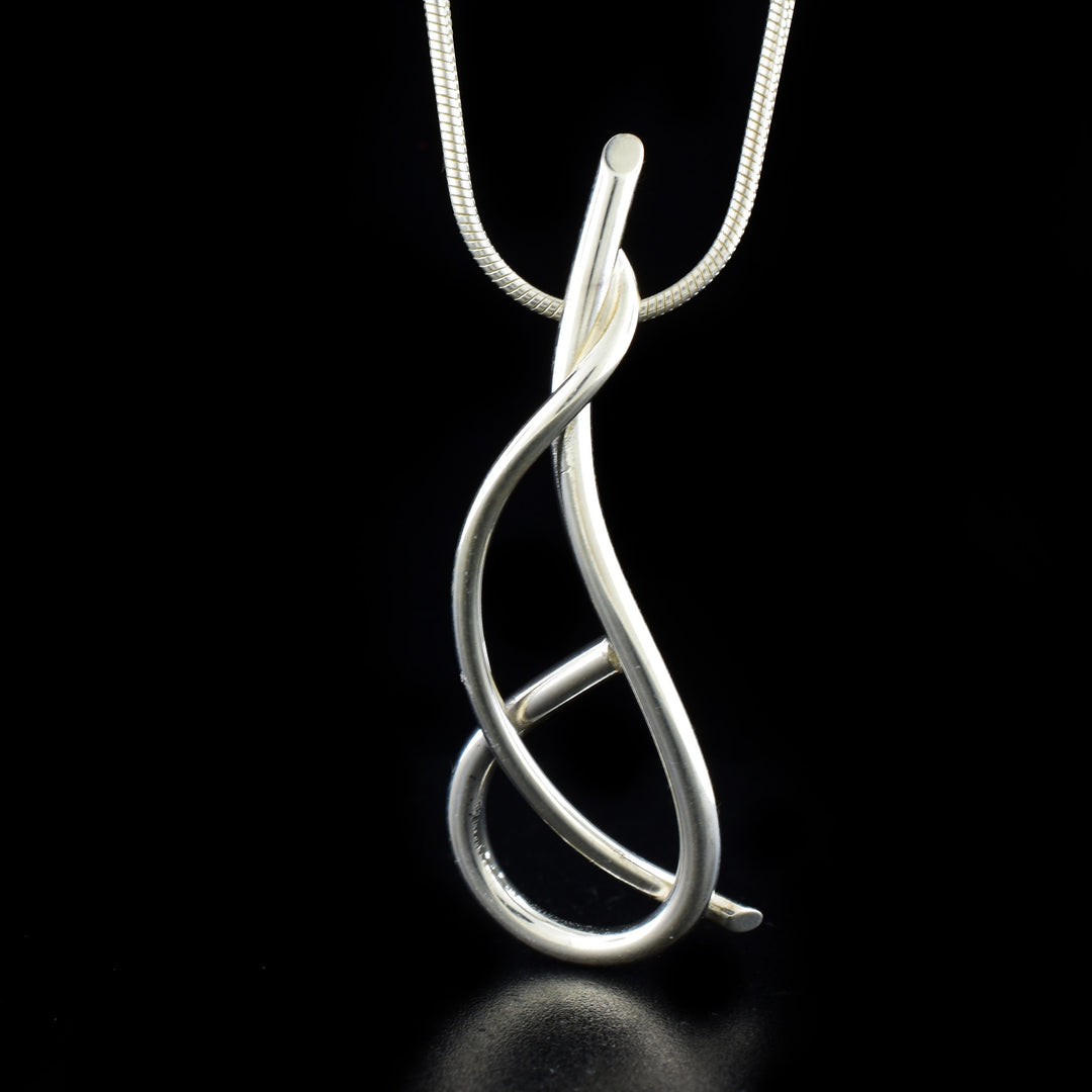 Unique pendant necklace by artist Lynda Constantine. She used sterling silver to create the pendant. Sterling silver snake chain included. Pendant measures 2" x 0.69" and chain is 18" long.