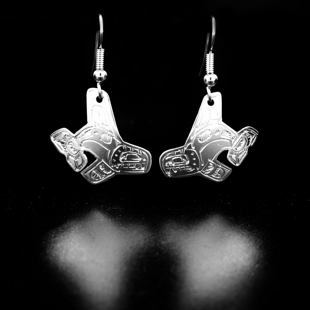 Stunning swimming orca earrings hand-carved by Coast Salish artist Gilbert Pat. Made of sterling silver. Each earring measures 1.63" x 0.31" including hook.