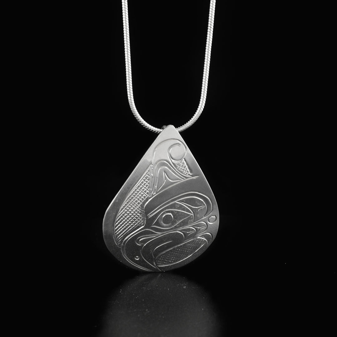 This Thunderbird pendant is made from sterling silver and has a wide teardrop shape to it. There is a depiction of the Thunderbird's face that has been beautifully carved into the surface of the piece.