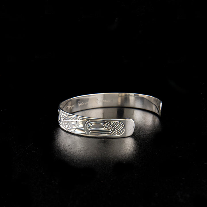 Sterling silver bear and salmon bracelet hand-carved by Kwakwaka'wakw artist Victoria Harper. 6.25" long with 1.25" gap. 0.38" wide.
